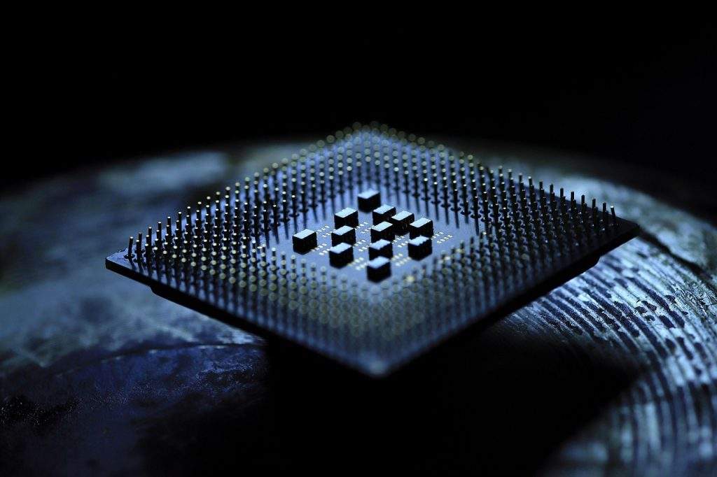 2026 煙霧實驗室：電子煙主機專用晶片的底部微觀特寫，清晰展示密集的金屬封裝針腳與半導體底座結構，用於實證文章中關於大功率輸出穩定性與電流修復技術的底層硬體架構。