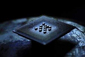 2026 煙霧實驗室：電子煙主機專用晶片的底部微觀特寫，清晰展示密集的金屬封裝針腳與半導體底座結構，用於實證文章中關於大功率輸出穩定性與電流修復技術的底層硬體架構。